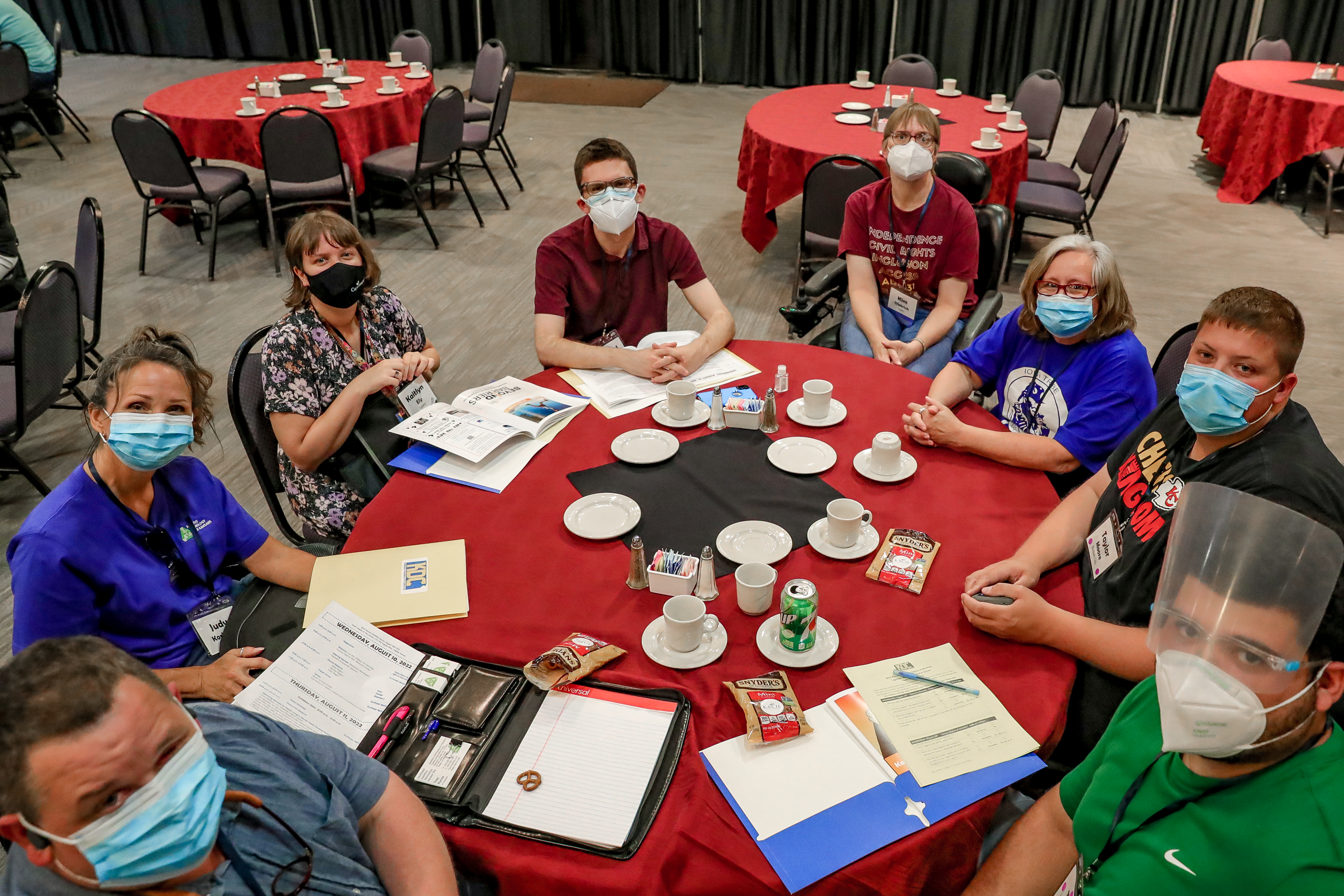 Employees of Topeka Independent Living Resource Center take a photo while sitting around a roundtable.