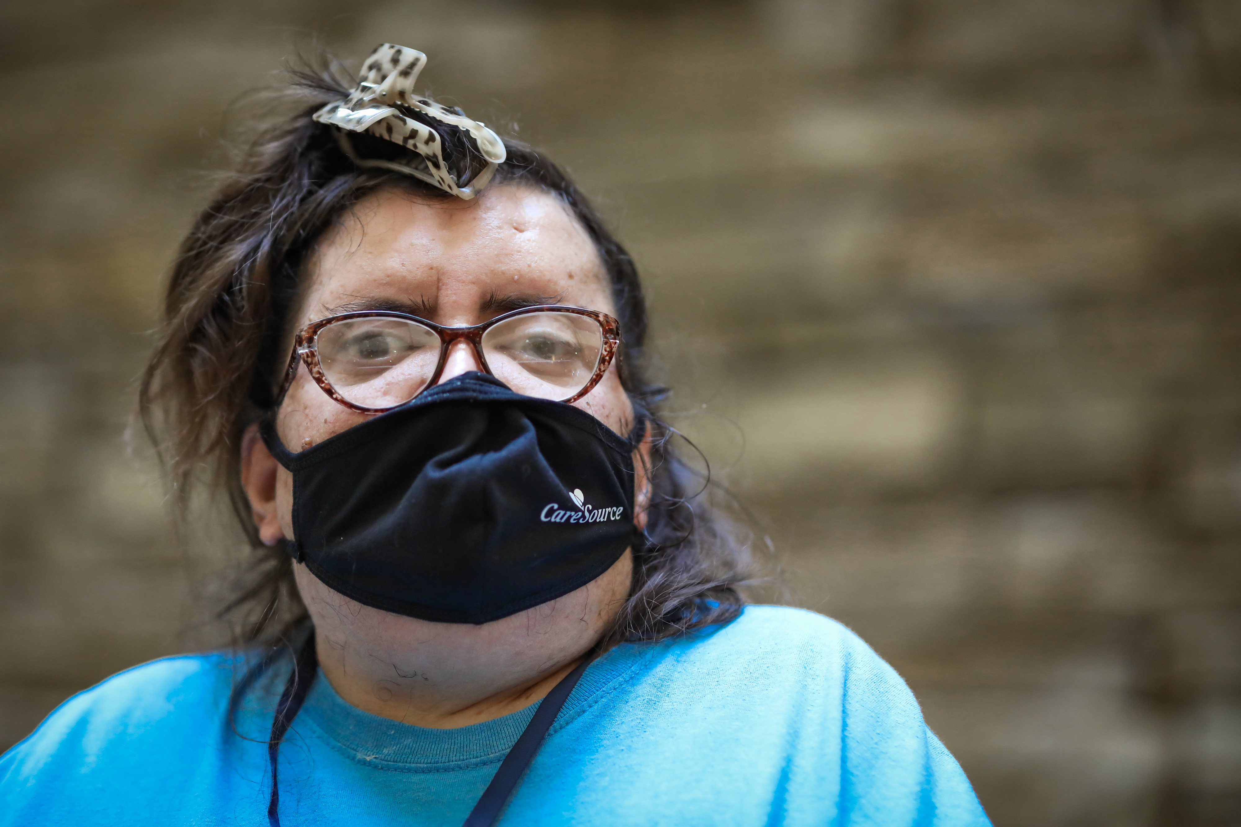 Close up of a female participant at the Caucus wearing glasses, a blue shirt, and CareSource mask.