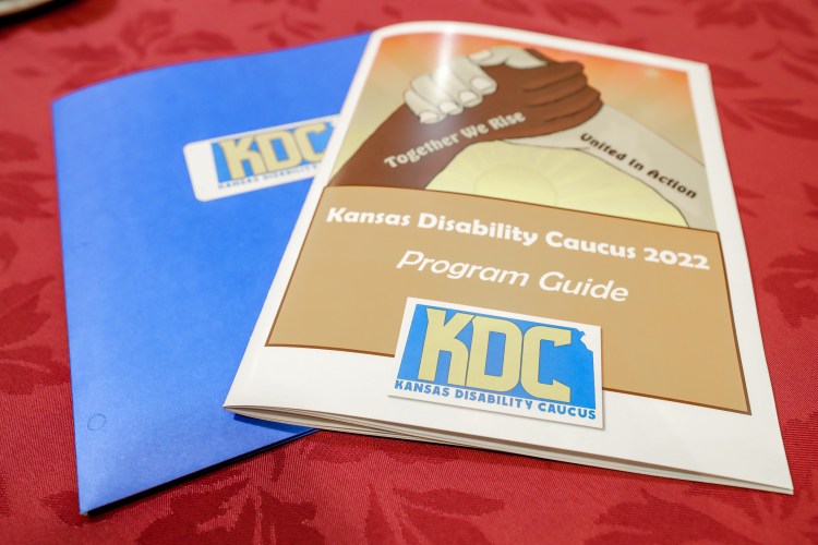 A 2022 Caucus folder and program laying on a table